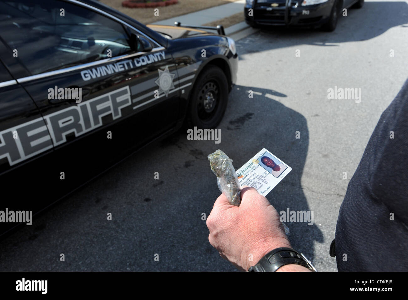 Mar 15, 2011 - Norcross, Georgia, Stati Uniti - Sgt. Greg Cappella con Gwinnett County Sheriff ufficio del tribunale civile di divisione, detiene la patente di guida e un sacchetto di marijuana dopo resident Maurice Adams è stato arrestato per aver apparentemente un eccezionale garantisce e possesso di marijuana, mentre servin Foto Stock
