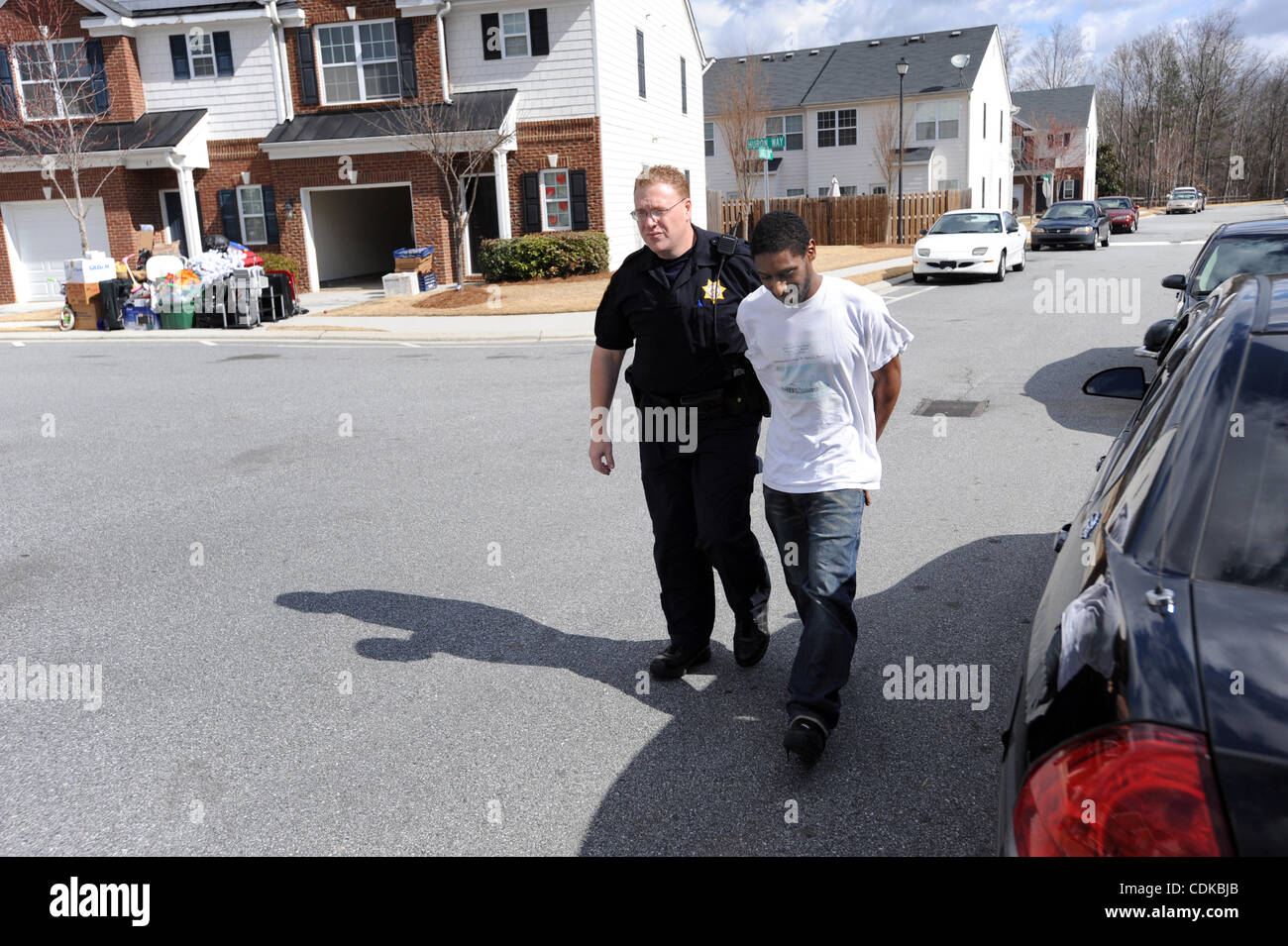 Mar 15, 2011 - Norcross, Georgia, Stati Uniti - Il Vice T. Wigenton (L) con l'Gwinnett County Sheriff ufficio del tribunale civile di divisione, accompagnatrici resident Maurice Adams dopo il suo arresto per presunto avente un eccezionale garantisce e possesso di marijuana, mentre si serve di un sfratti in Norcross, Georgia USA Foto Stock