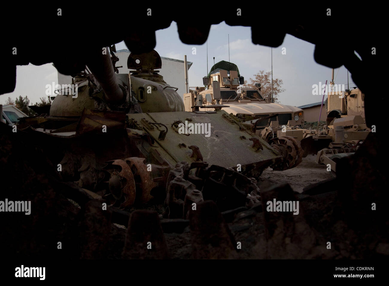 Mar 25, 2011 - Qalat, Provincia di Zabul, Afghanistan - un distrutto serbatoio sovietica riposa accanto a militari statunitensi MRAP (miniera resistente imboscata protetto) i veicoli a motore la piscina a inoltrare una base operativa (FOB) Smart nella capitale provinciale di Qalat nella provincia di Zabul. Con sede centrale a livello FOB Smart, il leader Foto Stock