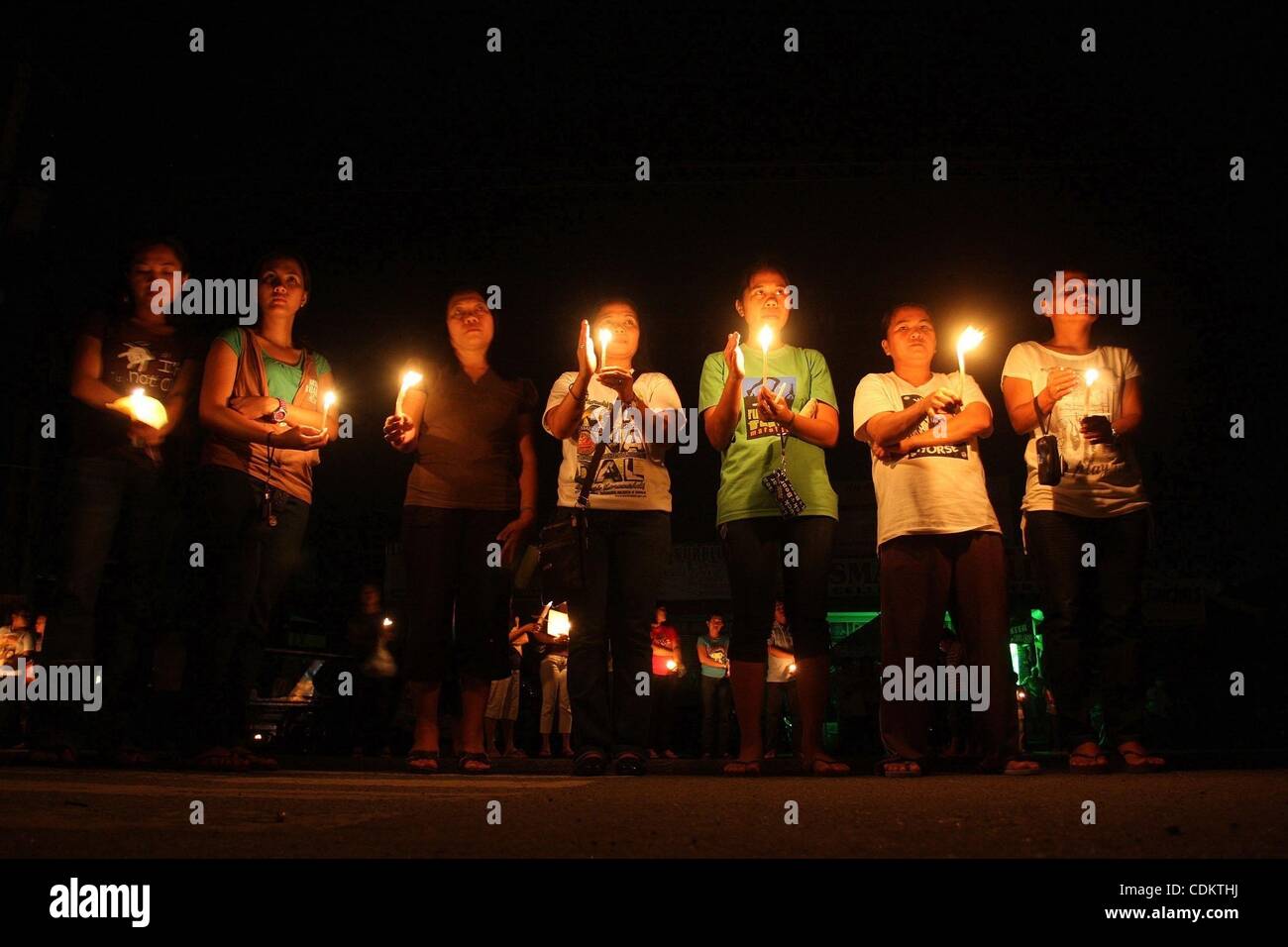 Mar 26, 2011 - Koronadal, Filippine - Ambientalisti nel sud della città filippina di Koronadal sull isola di Mindanao accendono le candele sulle strade come essi si uniscono il mondo a spegnere le luci per un ora per la Terra ora sabato notte. Ora della Terra, una iniziativa globale Powered by World wildlife Foto Stock