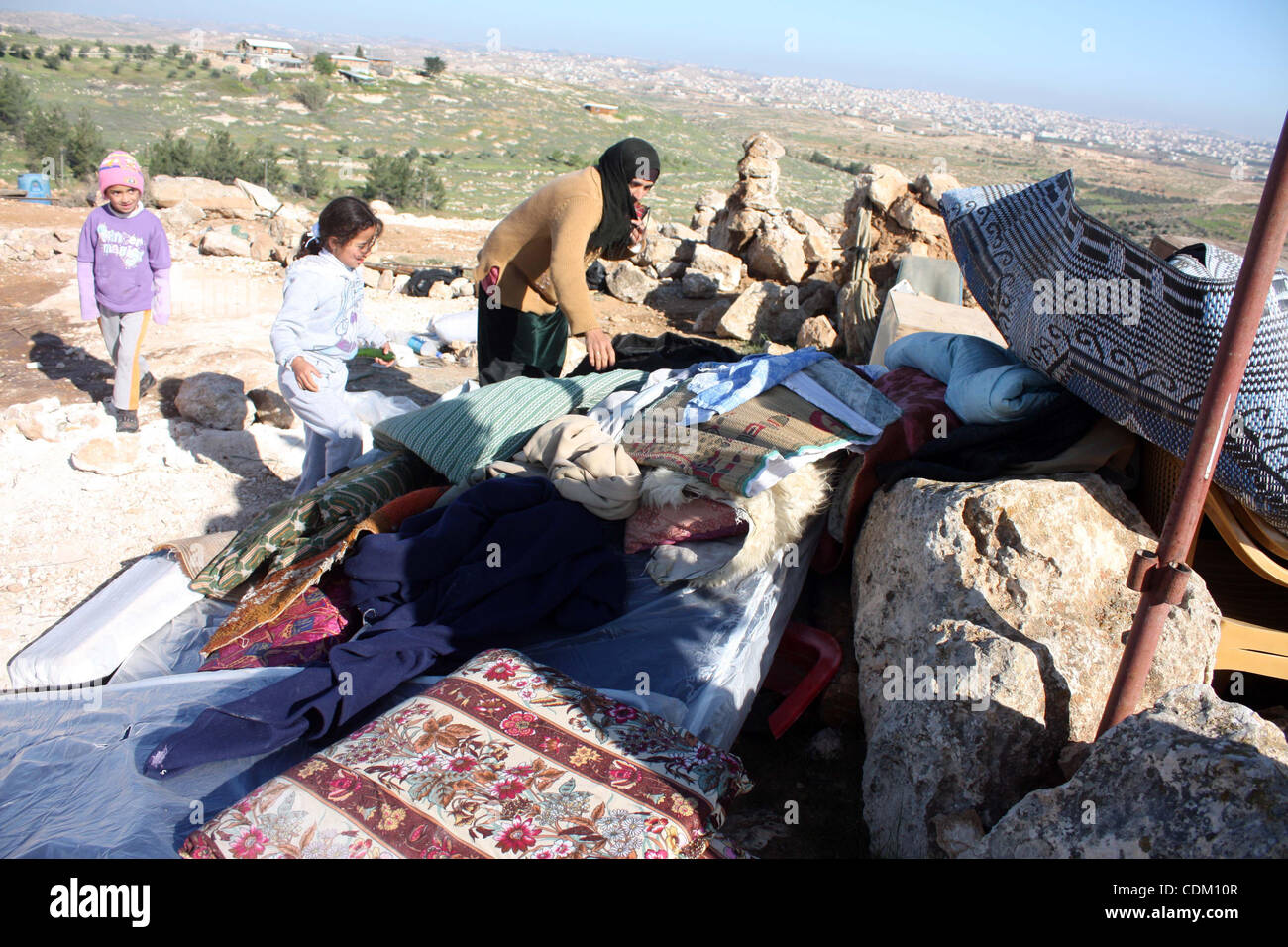 Famiglia palestinese cercare cose dalle macerie della loro casa dopo che era stato distrutto presumibilmente da esercito israeliano trattori inizio il 29 marzo 2011, in Cisgiordania villaggio di Yatta vicino a Hebron. La casa si trova nella cosiddetta area C, chiuso di zona militare dove Israele esercita piena cont Foto Stock