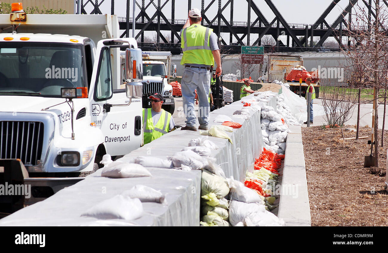 Gli equipaggi con il Davenport opere pubbliche sono state occupate pila dei sacchi di sabbia sulla parte superiore di un argine temporaneo un muro costruito sul Fiume guidare nel centro cittadino di Davenport, Iowa mercoledì 13 aprile, 2011. Il fiume Mississippi era al 16,8 piedi al Rock Island, Illinois stazione di monitoraggio. Stadio di inondazione è di 15 piedi. Il fiume è in avanti Foto Stock