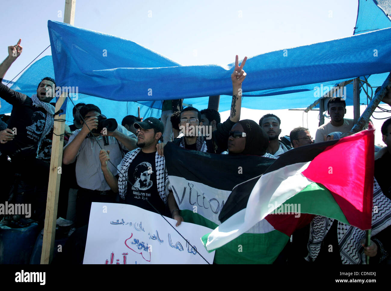 Palestinesi e attivisti stranieri di protesta contro il rapimento e l uccisione di italiano attivista per i diritti umani Vittorio Arrigoni da un gruppo di Salafist di islamista radicale al porto di Gaza City, il 20 aprile 2011, un giorno dopo due sospetti in omicidio morì durante un Hamas raid della polizia in casa nella cen Foto Stock