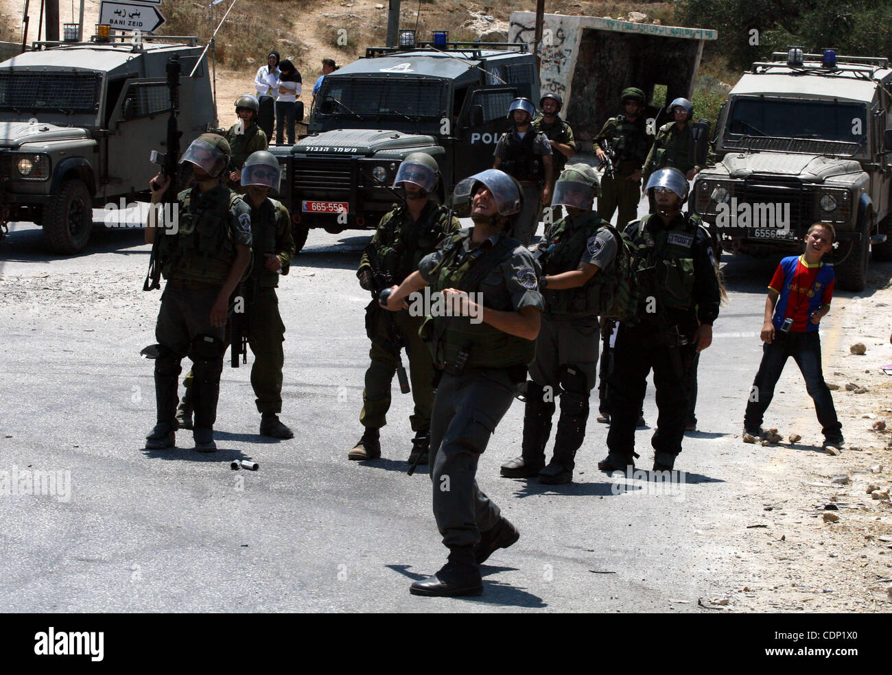 Un soldato israeliano scaglia gas lacrimogeni recipiente verso i manifestanti palestinesi durante scontri a seguito di una dimostrazione contro l'occupazione israeliana e di espansione degli insediamenti, il 15 luglio 2011 in Cisgiordania villaggio di Nabi Saleh Foto di Issam Rimawi Foto Stock