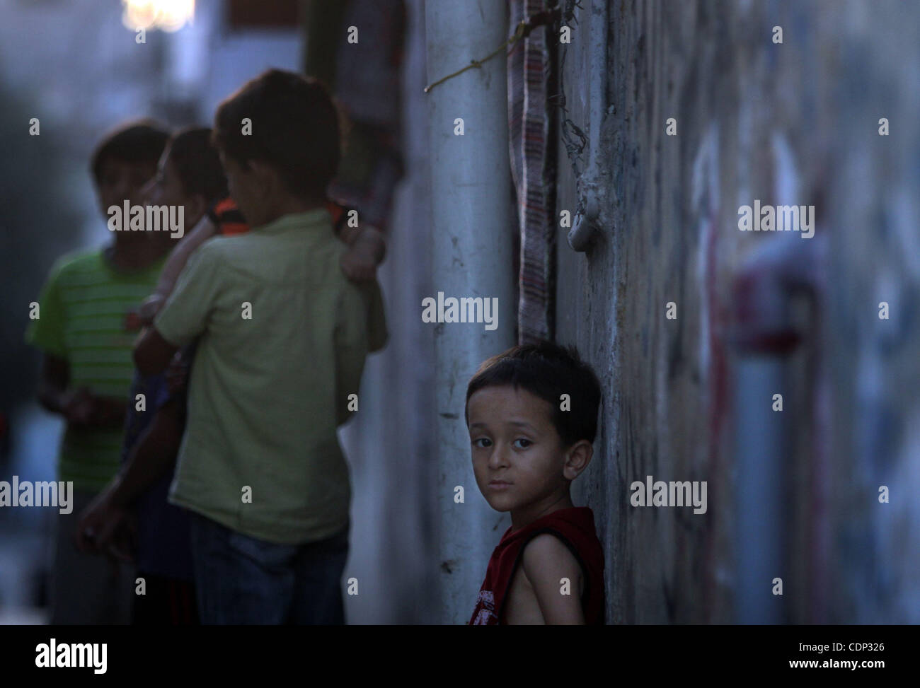 Un ragazzo palestinese si erge di fronte alla sua casa in Jabaliya Refugee Camp nella zona nord della Striscia di Gaza il 21 luglio 2011. Soccorso e lavori delle Nazioni Unite (UNRWA) consentirà di ridurre alcuni dei suoi servizi per i rifugiati palestinesi a causa di deficit di bilancio e la mancanza di fondi dei donatori. Foto di Ali Jadallah Foto Stock