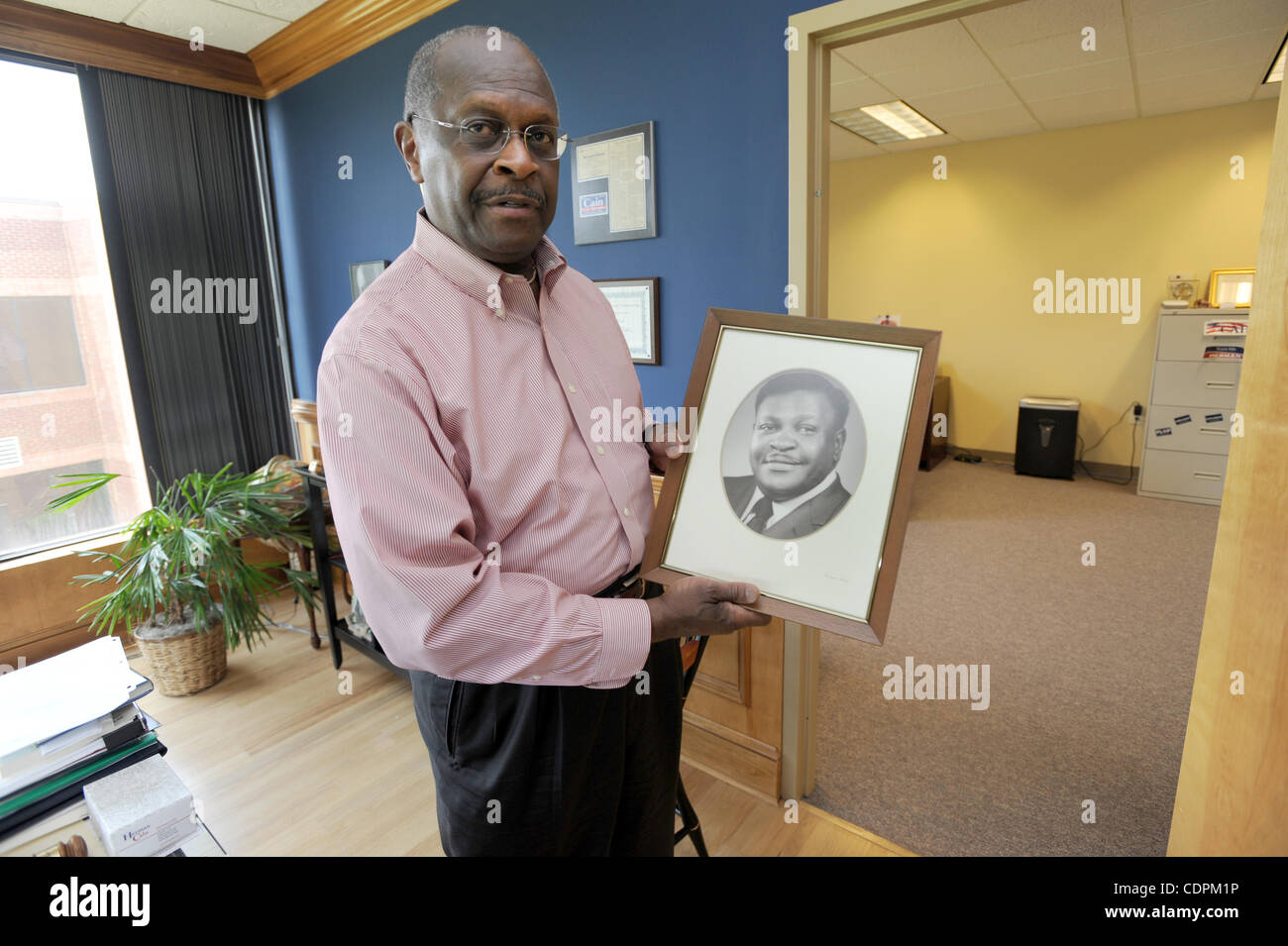 29 maggio 2011 - Stockbridge, GA, Stati Uniti - STOCKBRIDGE, GA - 29 Maggio: candidato presidenziale repubblicano Herman Cain detiene una foto del padre Luther presso il suo ufficio a Stockbridge, Georgia domenica 29 maggio, 2011. Caino è l'ex presidente di padrini Pizza e un conservatore radio talk show host. P Foto Stock