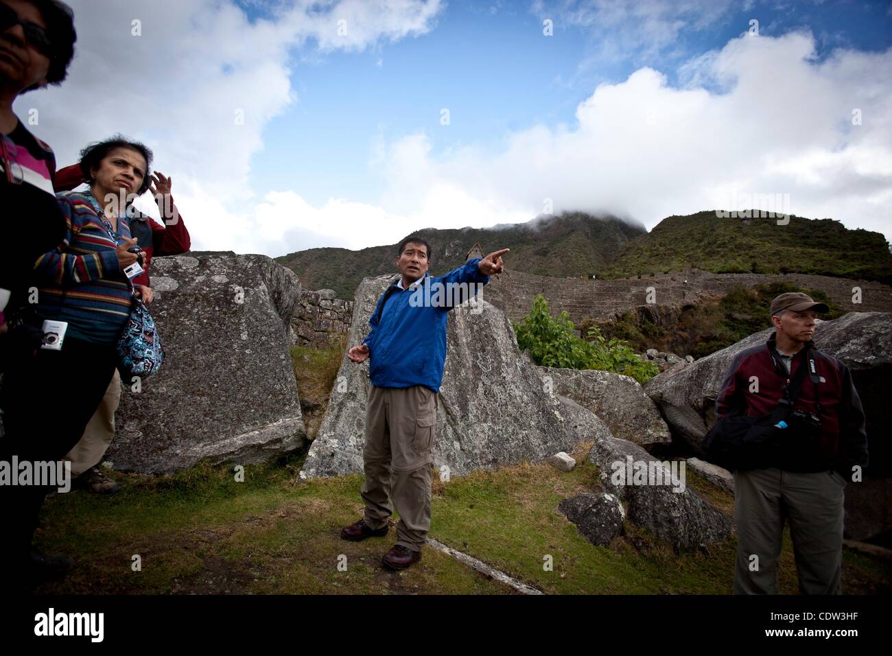 Jul 10, 2011 - Machu Picchu, Cusco Peru - un tour guida spiega la storia del Inka e la storia dietro il Machu Picchu. I turisti amano gli enigmatici cittadella Inca di Machu Picchu alta nelle Ande del Perù. Gli Inca costruito Machu Picchu in cima ad un picco andino 7,970 piedi (2.430 metri) alta. Il Perù celebrare Foto Stock
