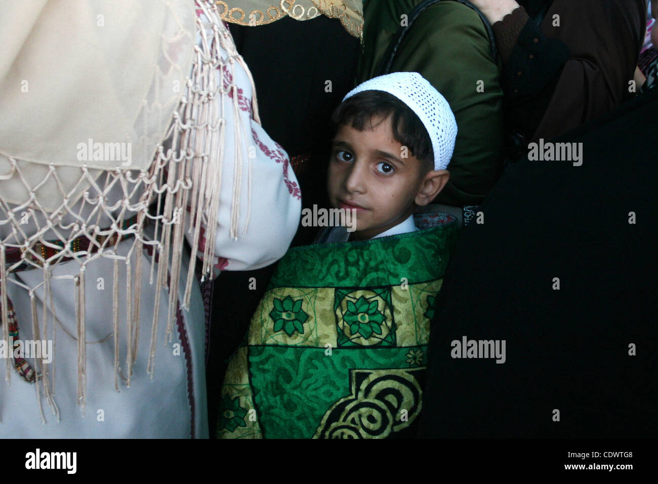 Agosto 5, 2011 - Ramallah, West Bank - un ragazzo palestinese con sua madre attendere per attraversare il checkpoint Qalandia sul loro modo di pregare presso la moschea Al Aqsa il primo venerdì di il mese del Ramadan, al checkpoint Qalandia tra la Cisgiordania città di Ramallah e Gerusalemme. I musulmani ac Foto Stock
