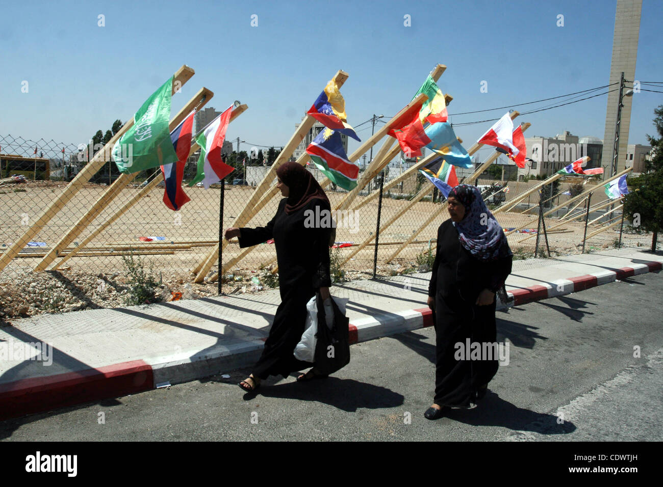 Le donne palestinesi a piedi passato le bandiere di paesi che hanno riconosciuto lo stato palestinese in Cisgiordania città di Ramallah il 7 agosto, 2011. Le bandiere sono state sollevate dagli enti locali dei gruppi di giovani in anticipo dell'U.N. Assemblea generale nel settembre dove i Palestinesi sperano di ottenere U.N. statualità riconoscimento. Foto Foto Stock