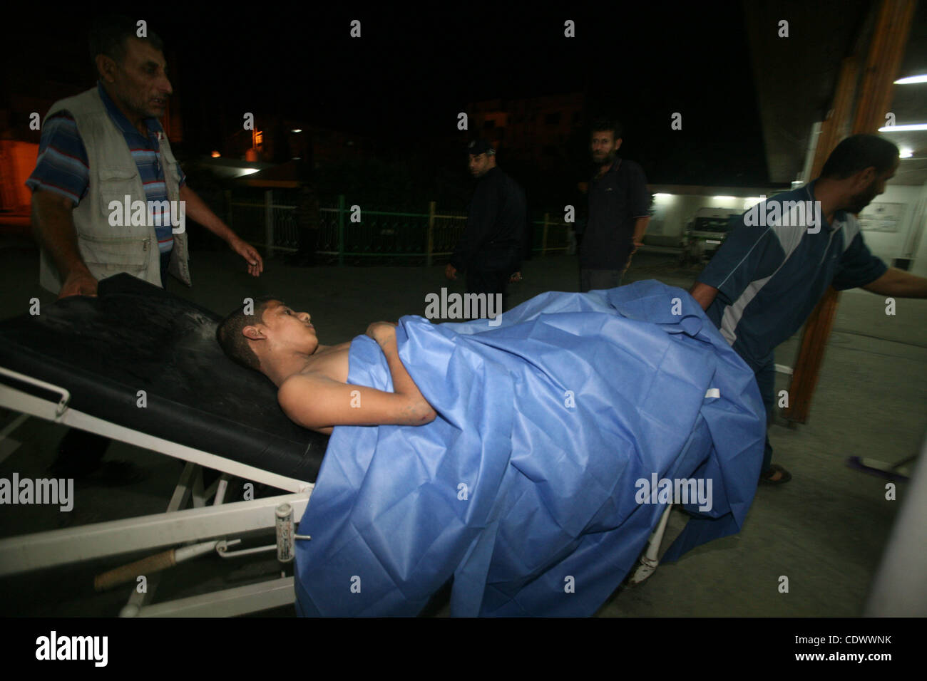 Palestinesi portano un ragazzo ferito in Shuhada El- Aqsa hospital seguenti shell israeliana nella Striscia di Gaza, Agosto 25, 2011. Foto di Ali Jadallah Foto Stock