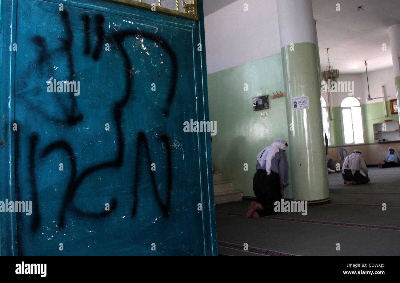 Palestinesi partecipare a pregare in una moschea la cui porta era vandalizzato con le parole ebraiche 'PR (prezzo Tag) Migron' in Cisgiordania settentrionale villaggio di Yatma, Giovedì, Settembre 8, 2011. Israeliani in Cisgiordania i coloni, nel frattempo, venuto sotto sospetto giovedì in l'ultima di una serie di attacchi contro Pales Foto Stock