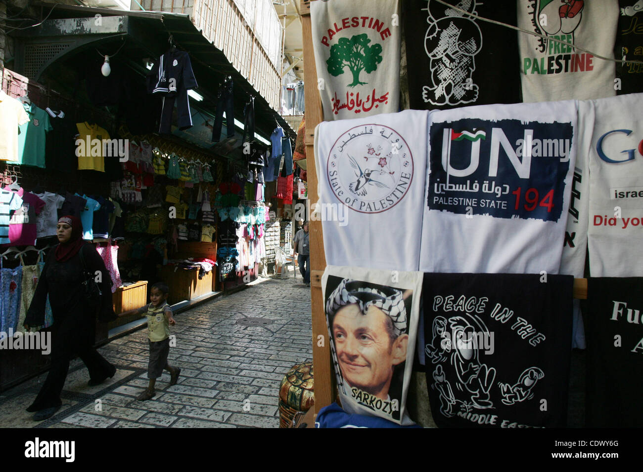 Sett. 18, 2011 - Gerusalemme, Israele - palestinesi a piedi passato un negozio di souvenir in Gerusalemme la città vecchia di visualizzazione di T-shirt con immagini del Presidente francese che indossano il tradizionale copricapo arabo keffiyeh. I palestinesi sono stati la campagna di sostegno di una creazione di uno Stato palestinese 194 offerta nel Regno Nazione Foto Stock