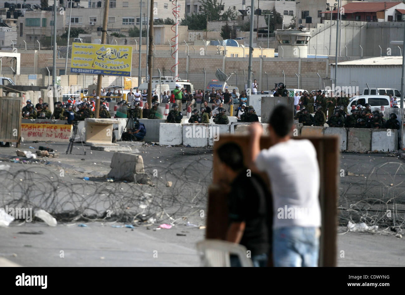 Gli uomini palestinesi scagliare pietre contro soldati israeliani durante scontri al checkpoint Qalandia vicino a Ramallah, il 23 settembre 2011. Rapporti di stato israeliano che i servizi di sicurezza erano in allarme elevato attraverso il paese, pronti a rispondere ad eventuali disordini risultanti da un Palestinese bid a cercare l'appartenenza all'ONU in Foto Stock