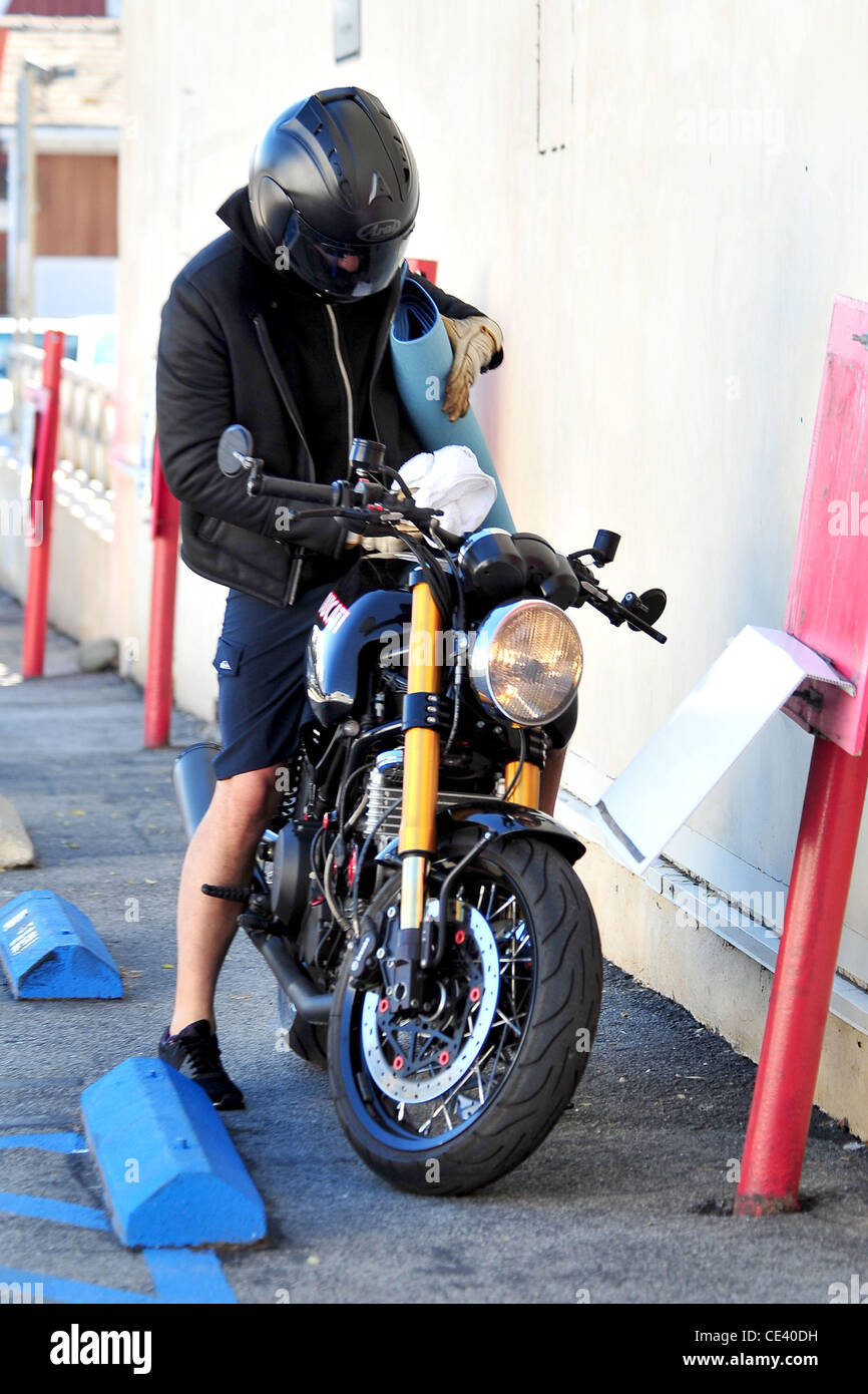 Orlando Bloom ha le mani piene come egli lascia uno studio di yoga in Santa  Monica indossa il suo casco del motociclo di Los Angeles, California -  06.12.10 Foto stock - Alamy