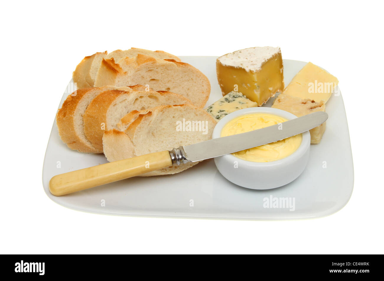 Pane formaggio e burro su una piastra con un coltello isolata contro bianco Foto Stock