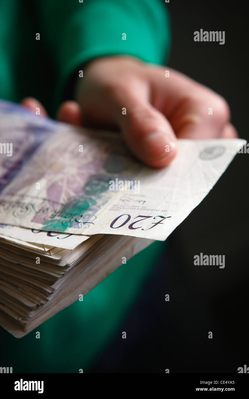 Tenendo la ventola del denaro £20 note GBR valuta sterlina mani stash borra prendendo nota off Foto Stock