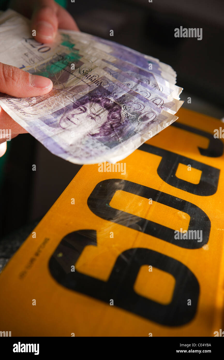 Tenendo la ventola del denaro £20 note GBR sterling valuta la targhetta del numero di frodi illegale Foto Stock