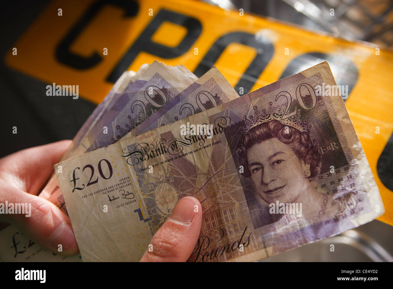 Tenendo la ventola del denaro £20 note GBR sterling valuta numero di targa Foto Stock