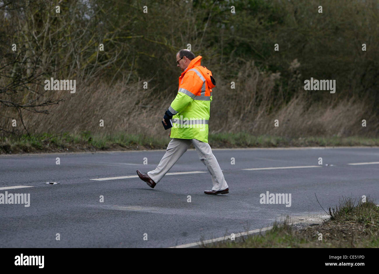 Un investigatore misure un area di strada erano un fatale incidente stradale si è verificato. Foto di James Boardman. Foto Stock