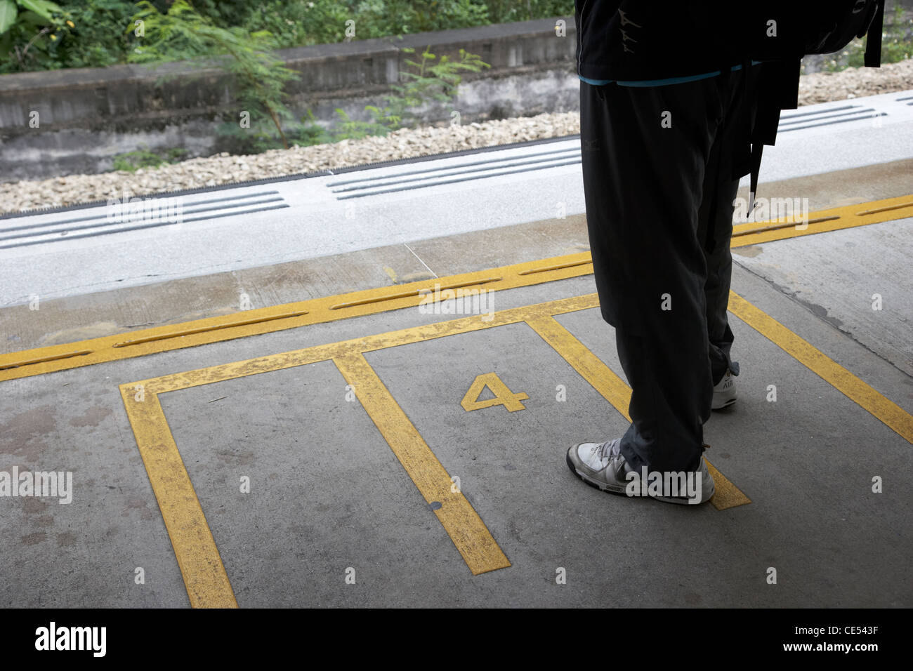 Uomo in piedi sul carrello i contrassegni di entrata sulla piattaforma a Sha Tin sulla stazione Mtr overground line ex kcr Kowloon Canton rail Foto Stock