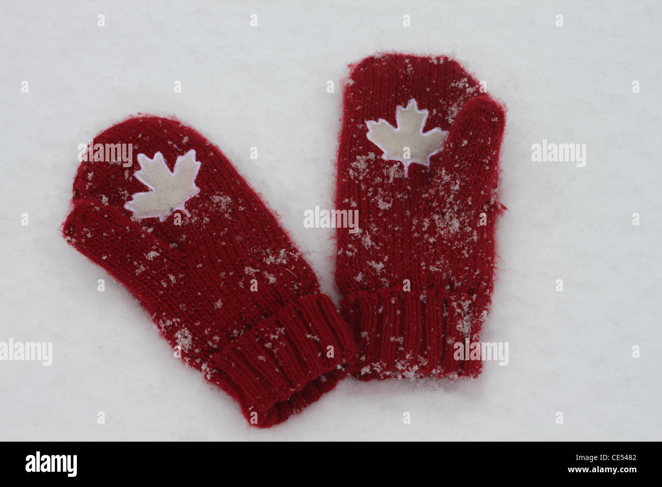 Coppia di Canada rosso guanti di lana di fianco a fianco sullo sfondo innevato Foto Stock