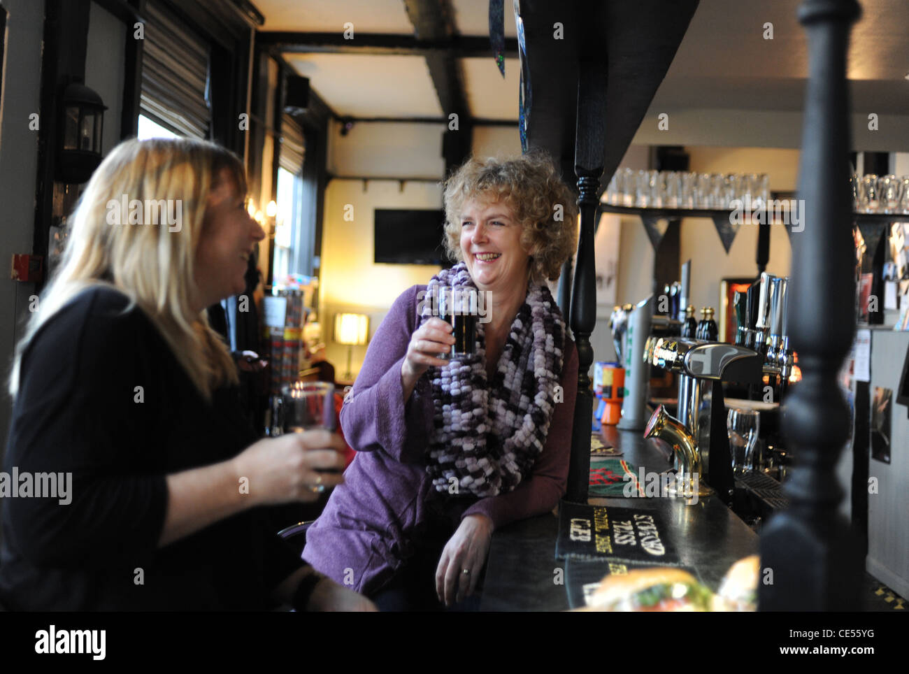 Due donne a gustare un drink in un British pub bar Brighton SUSSEX REGNO UNITO Gennaio 2012 Foto Stock