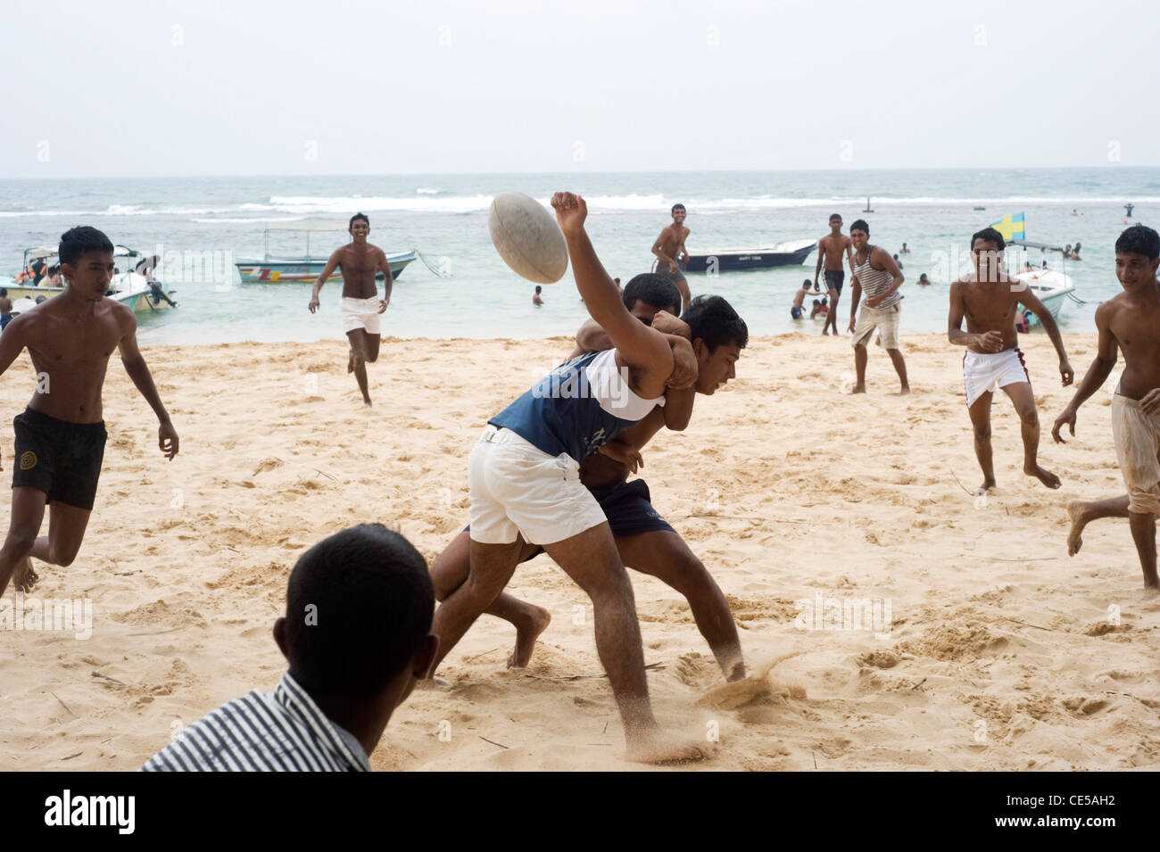 I giovani cittadini dello Sri Lanka plaing calcio sulla spiaggia Foto Stock