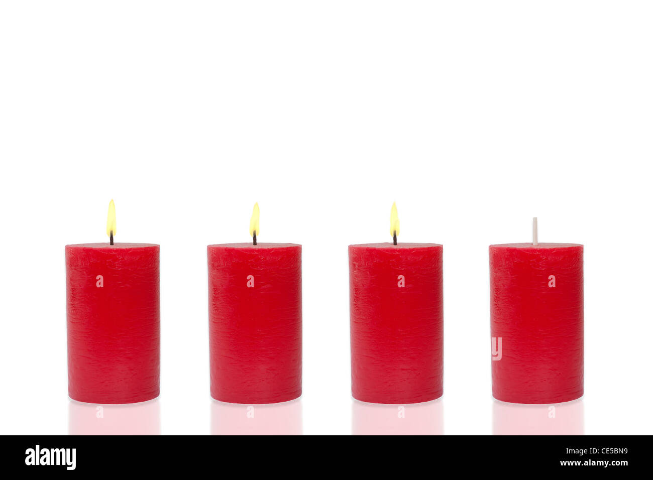Quattro candele rosse prima di sfondo bianco, tre masterizzare Foto Stock