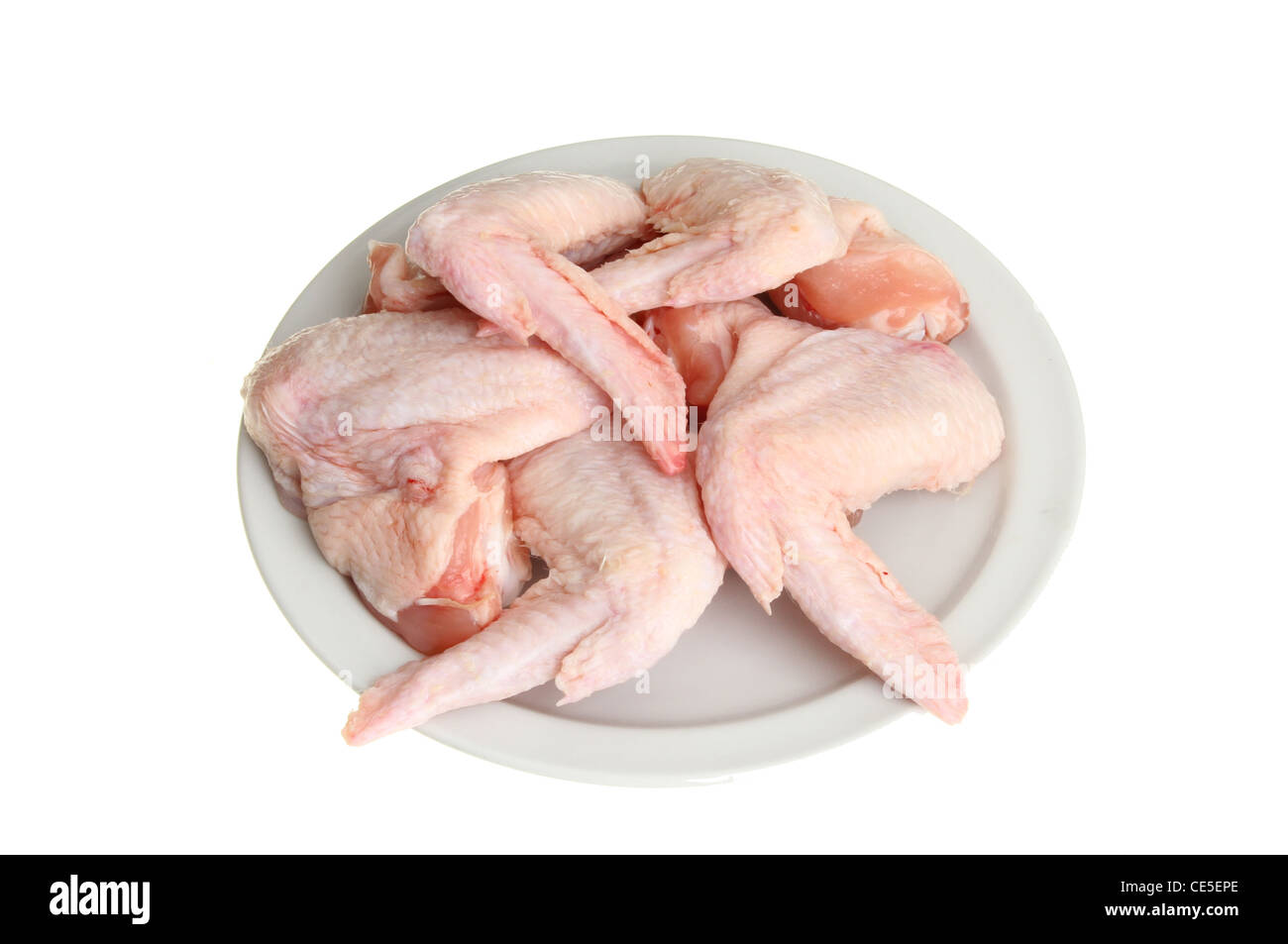 Materie di ali di pollo su una piastra isolata contro bianco Foto Stock