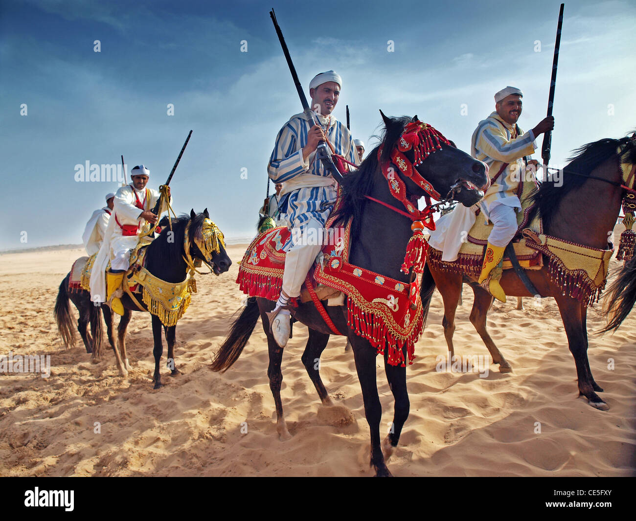Berber cavalieri eseguire sulla spiaggia a Essaouira, Marocco Foto Stock