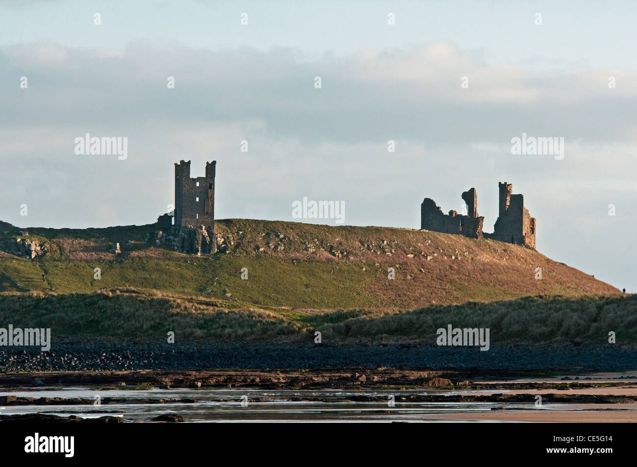 Il castello di Dunstanburgh fotografata da Embleton Bay sulla costa di Northumberland Foto Stock