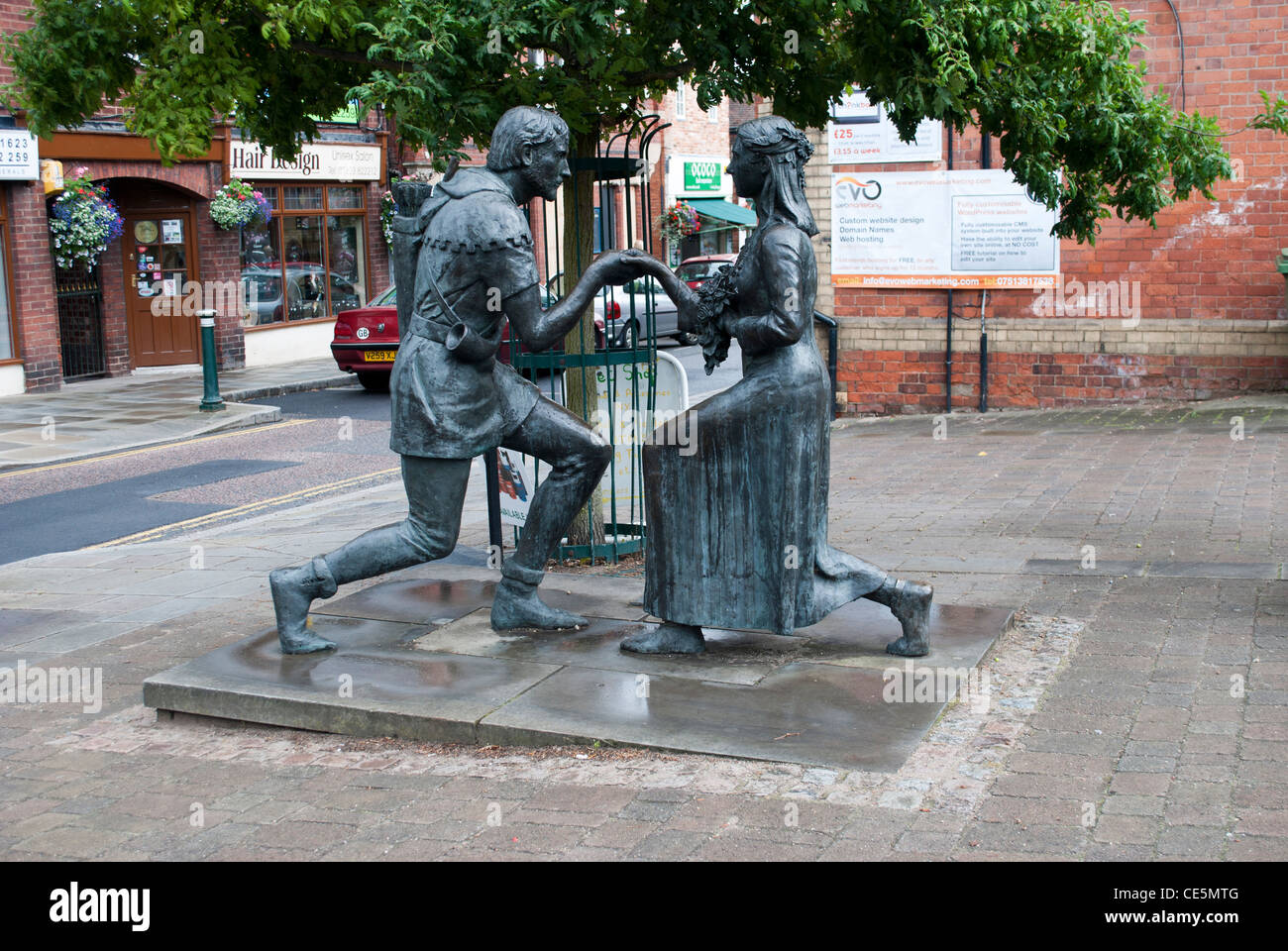 Statua di Robin Hood propone di Maid Marion nel villaggio di Edwinstowe Foto Stock
