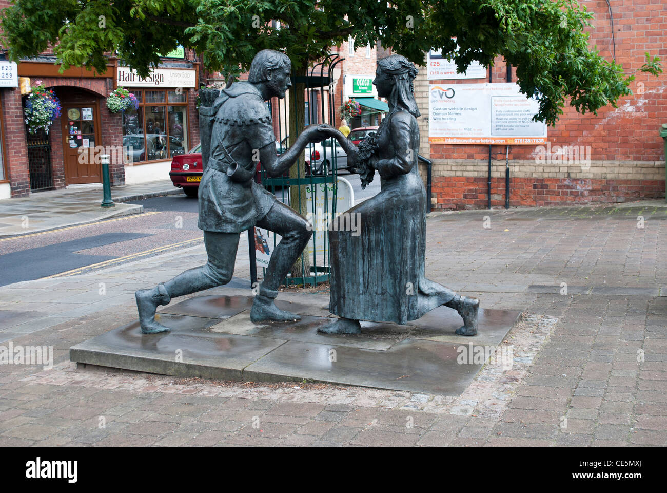 Statua di Robin Hood propone di Maid Marion nel villaggio di Edwinstowe Foto Stock