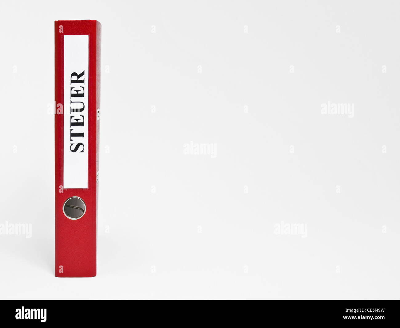Ein stehender roter Aktenordner mit der Aufschrift 'Steuer' | un file rosso in posizione verticale con l'etichetta tedesca 'Steuer'(imposta) Foto Stock