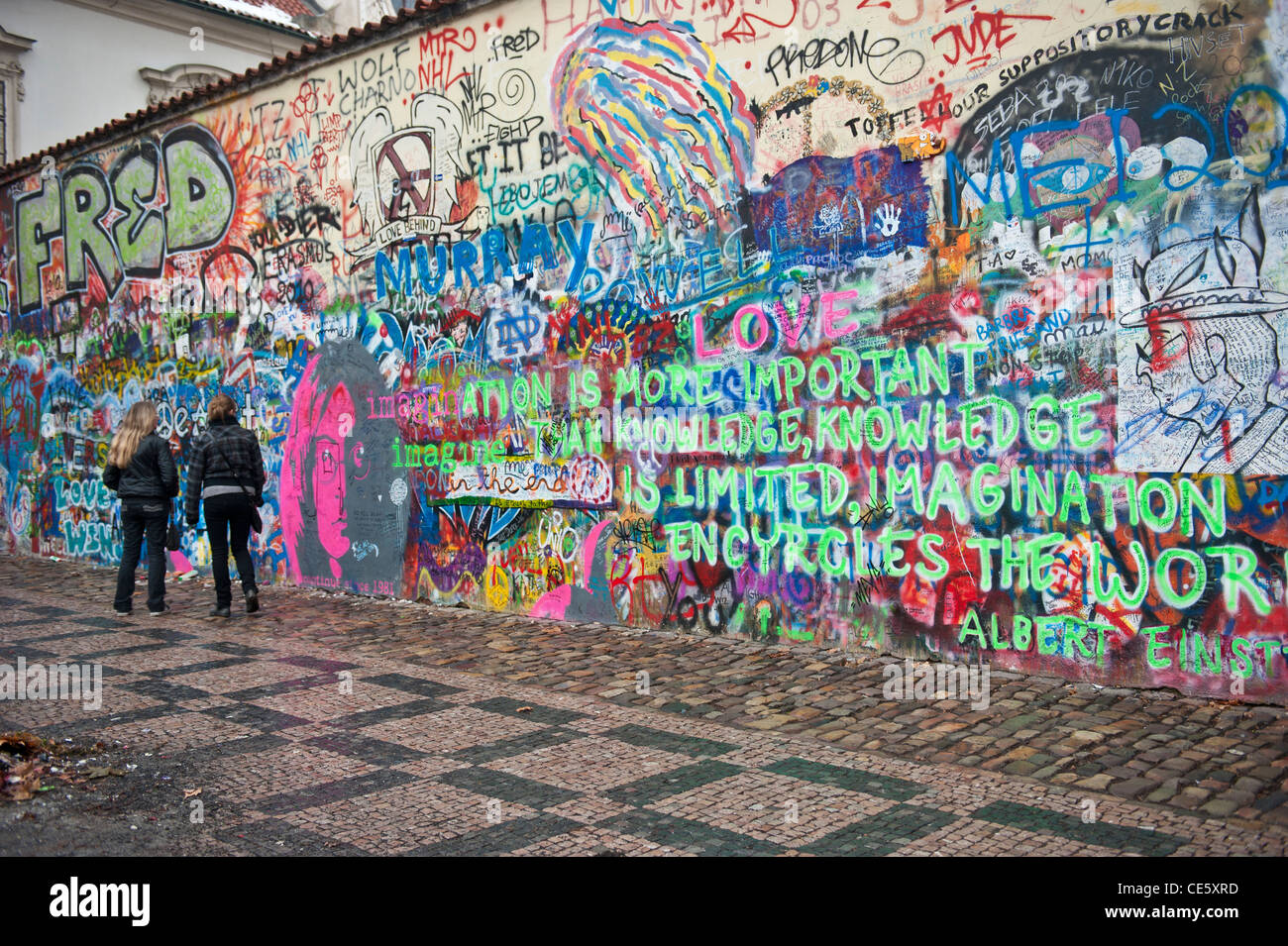 La gente a piedi nella parte anteriore del John Lennon tribute parete in Mala Strana di Praga, Repubblica Ceca Foto Stock