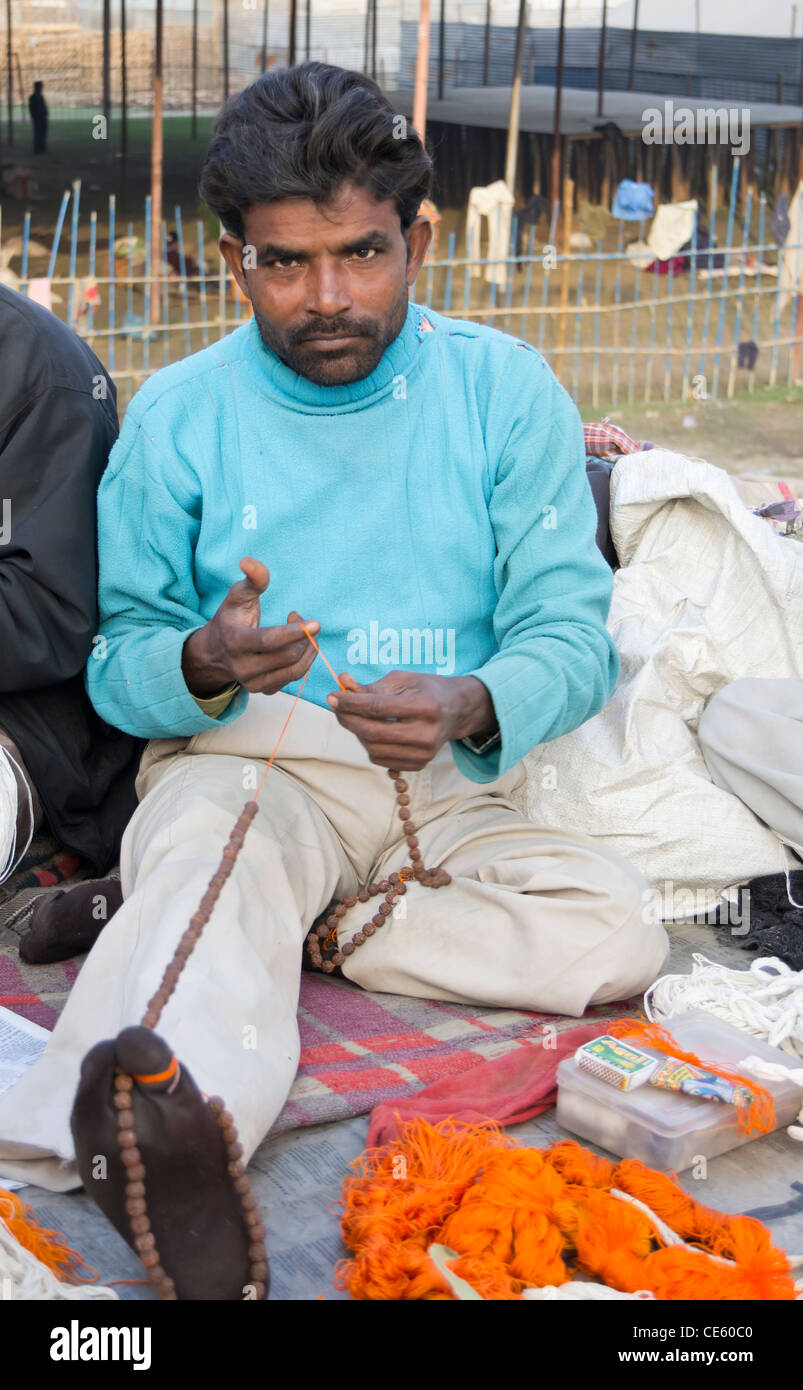 Uomo maturo rendendo un rosario per pellegrini indù a Magh Mela, Sangam, Allahabad, India Foto Stock
