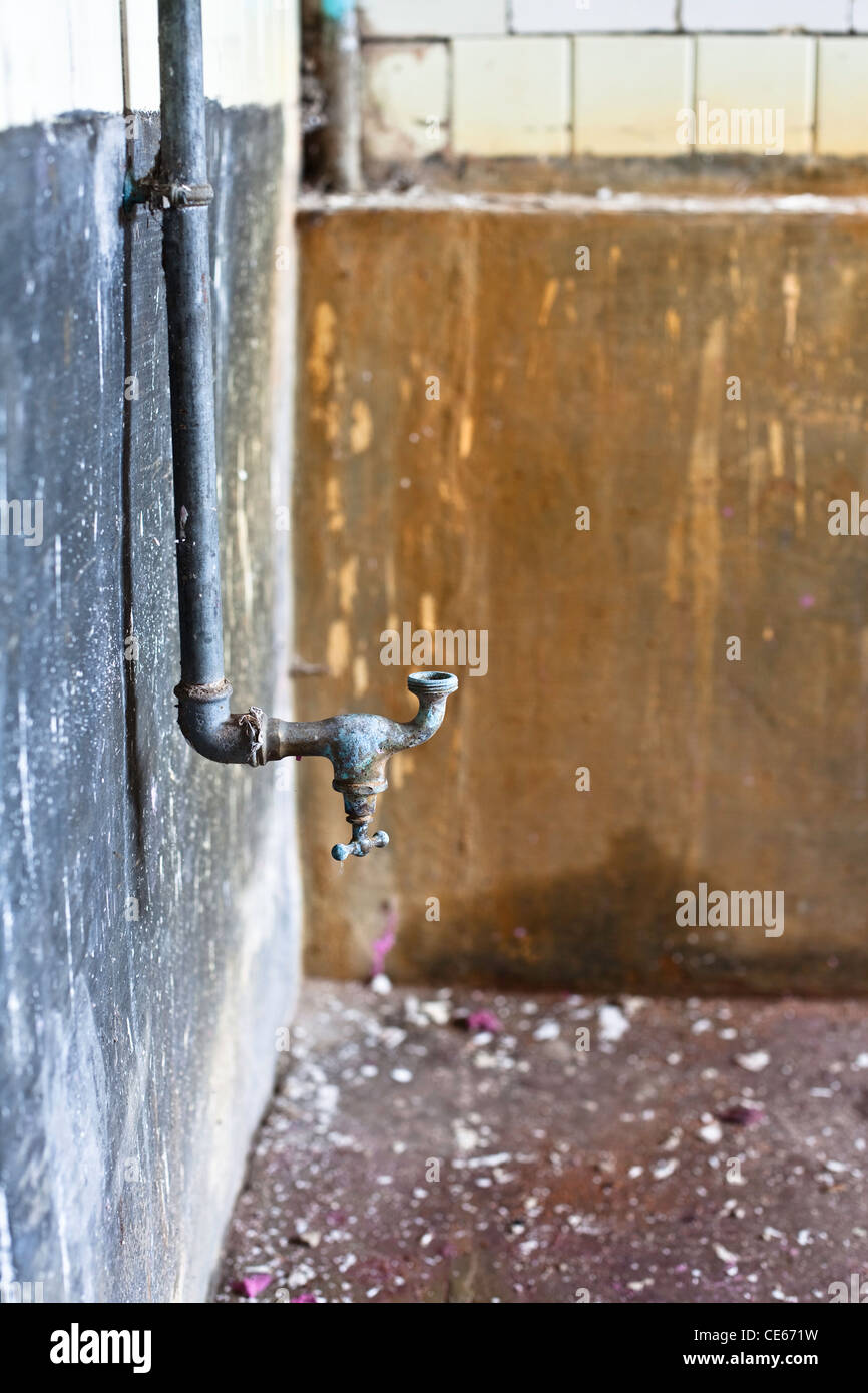 Rusty rubinetto di acqua nella vecchia casa abbandonata Foto Stock