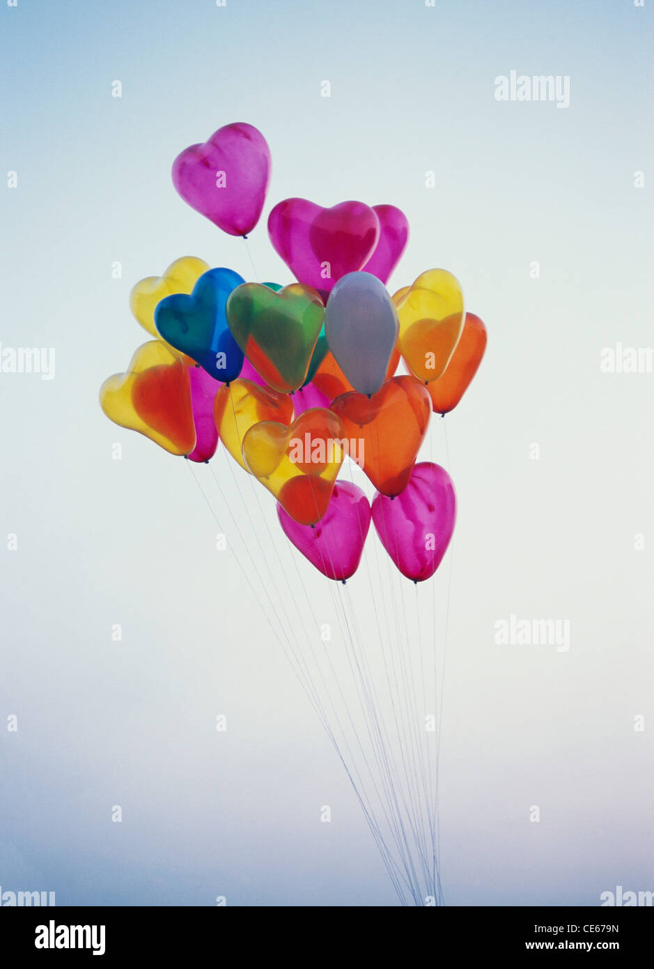 Palloncini colorati di elio a forma di cuore che galleggiano sopra nel cielo Foto Stock