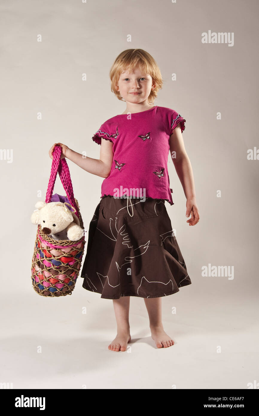 Bionda ragazza dai capelli bambino in studio, 5 anni con Teddy bear in borsa Foto Stock