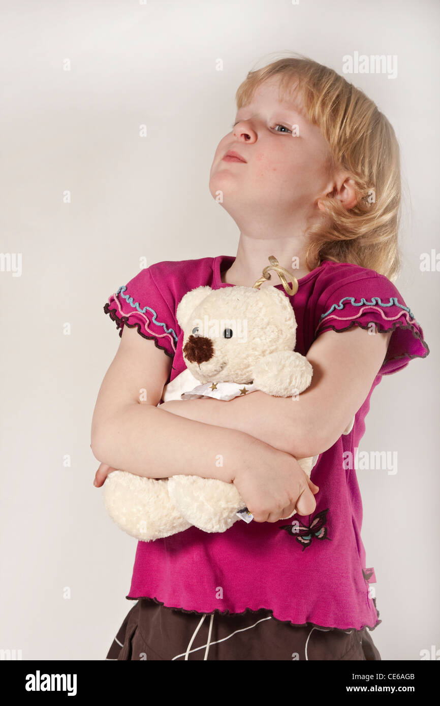 Bionda ragazza dai capelli bambino in studio, 5 anni con orsacchiotto Foto Stock