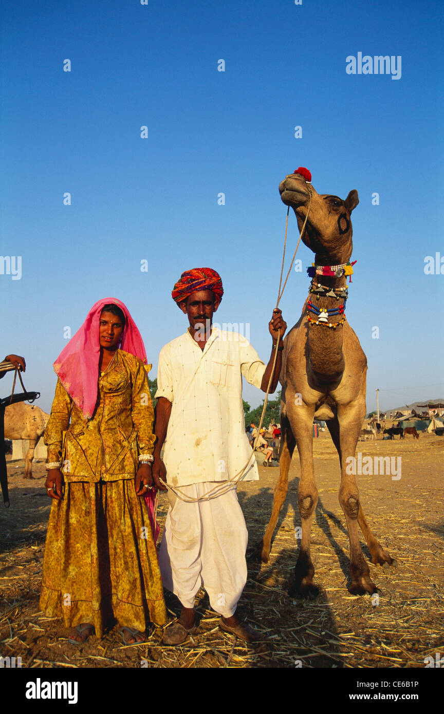 Coppia con cammello per vendita a Pushkar fair ; Ajmer ; Rajasthan ; India Foto Stock