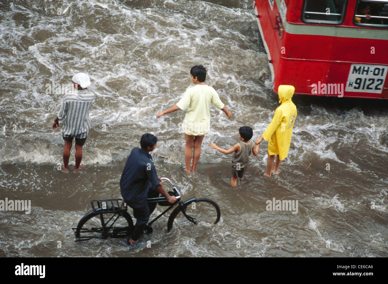 Piogge monsoniche inondazioni bus uomini bicicletta bambini ; Mumbai Bombay ; maharashtra ; india Foto Stock