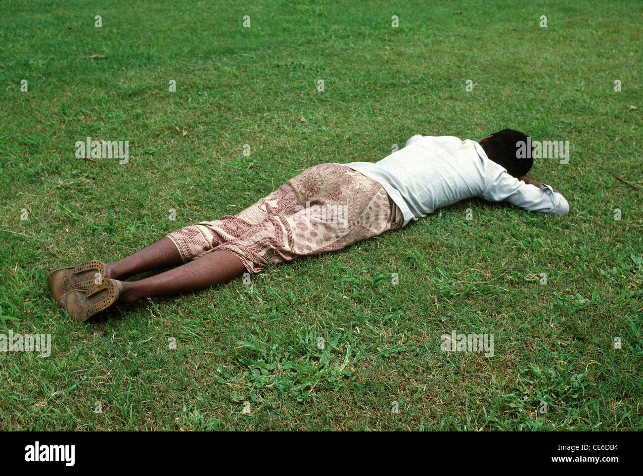 Uomo di dormire su stomaco su erba verde Foto Stock