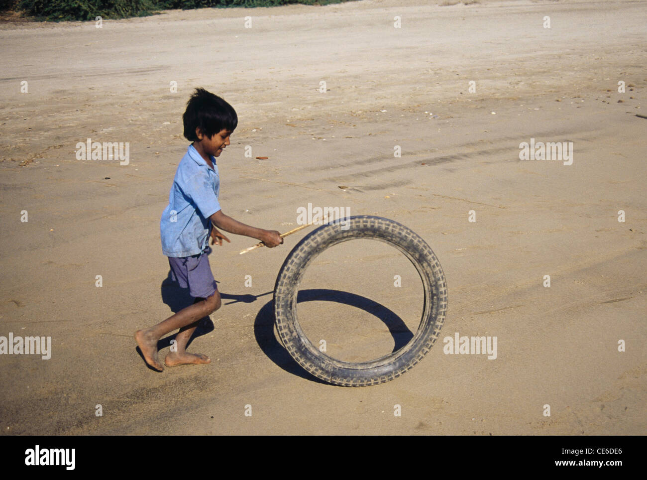Bambino rurale indiano che gioca con il pneumatico ; Diu ; territorio dell'Unione ; UT ; India ; Asia Foto Stock