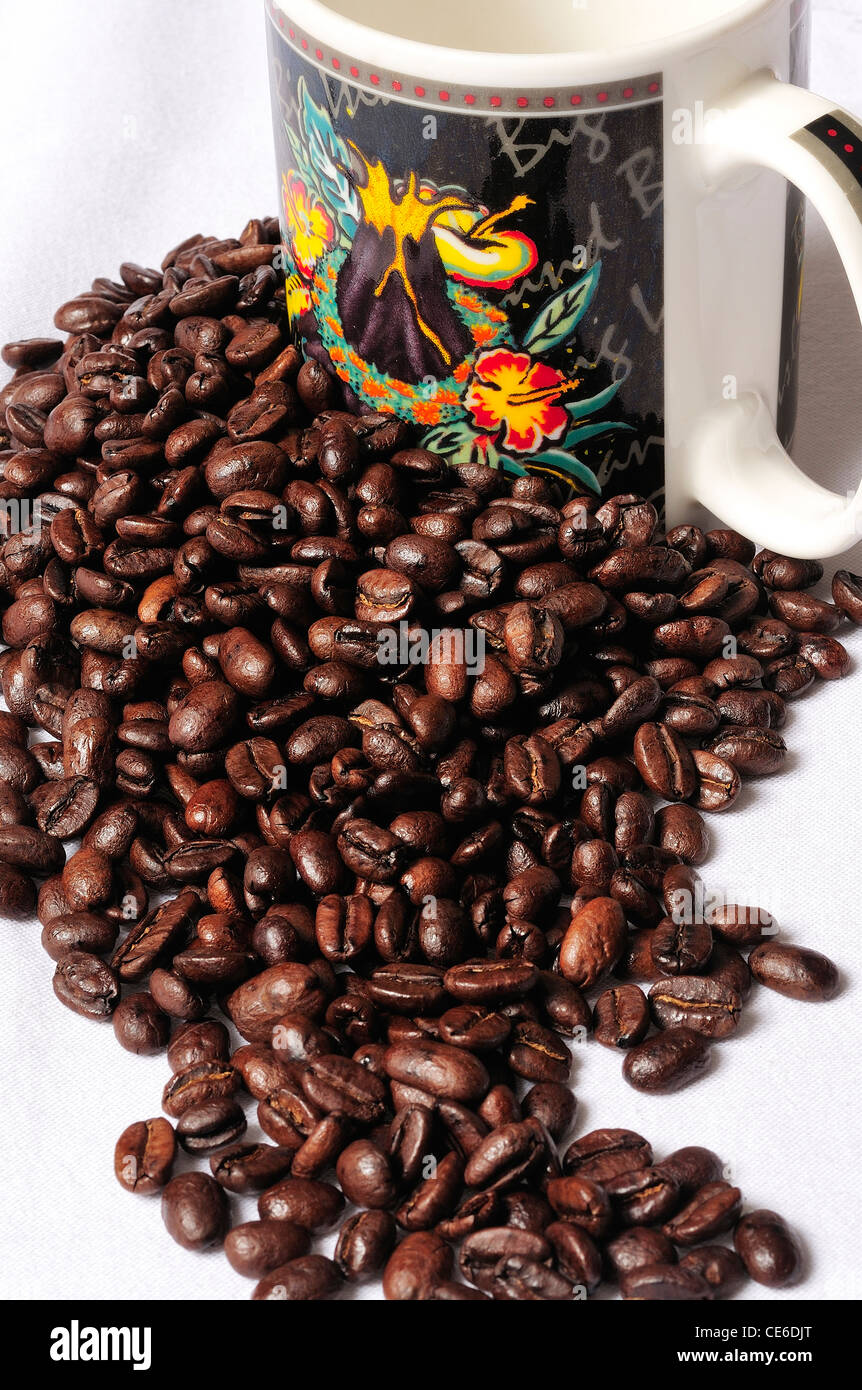 Schizzi di caffè in grani e coppa decorativa. Foto Stock