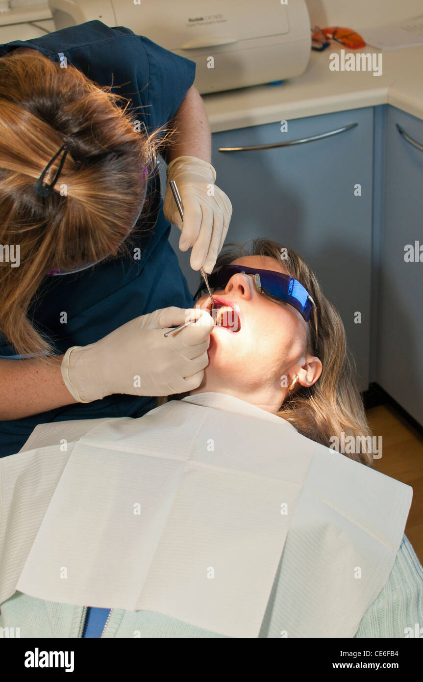 Dental hygenist pulizia di denti poltrona del dentista pulire hygene controllo check up ragazza bianco caucasico check up Foto Stock