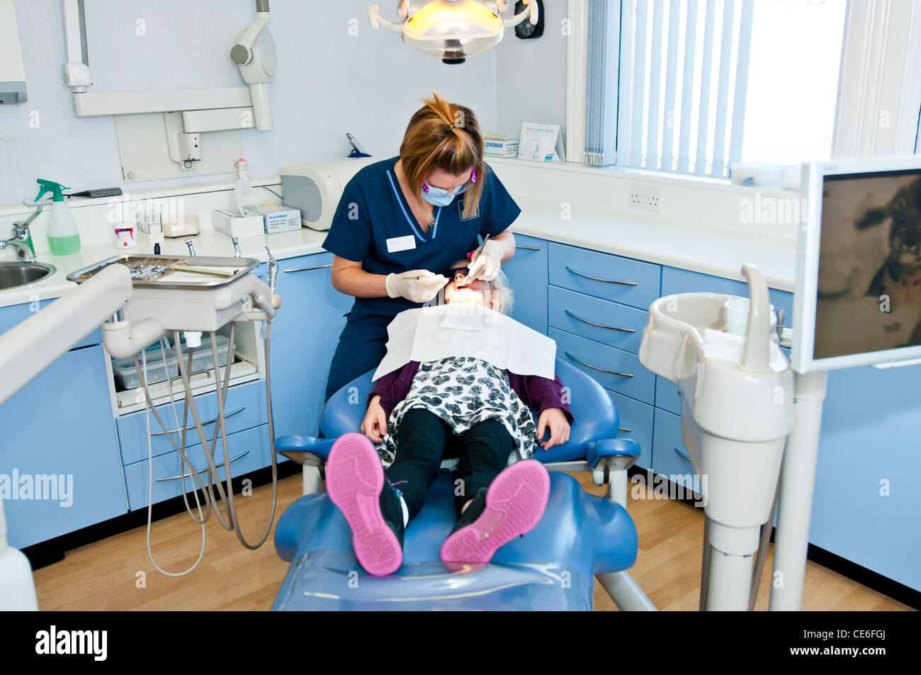 Dental hygenist pulizia di denti poltrona del dentista pulire hygene controllo check up ragazza bambino " cinque " anni di riempimento cauc cinque Foto Stock