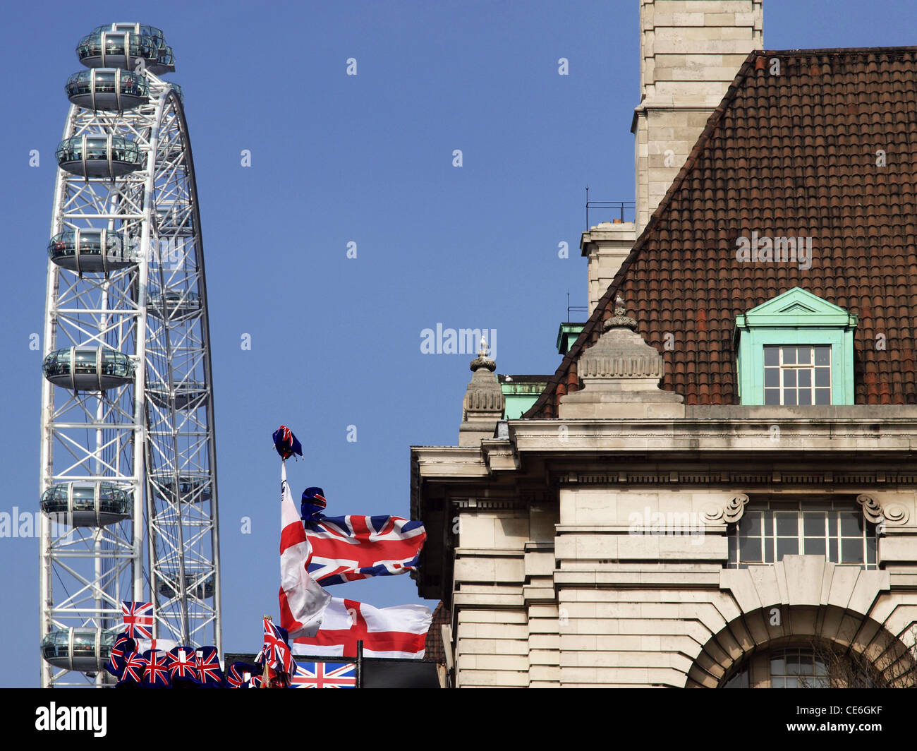 Il London Eye torreggia sopra County Hall e un negozio di souvenir stallo con la union jack flag. Foto Stock