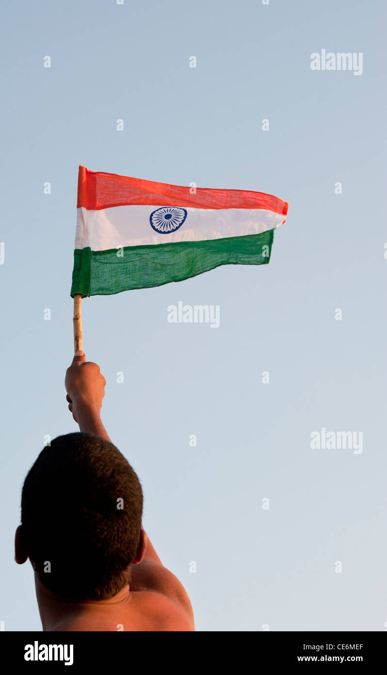 Uomo indiano tenendo una bandiera indiana contro un cielo blu. India Foto Stock