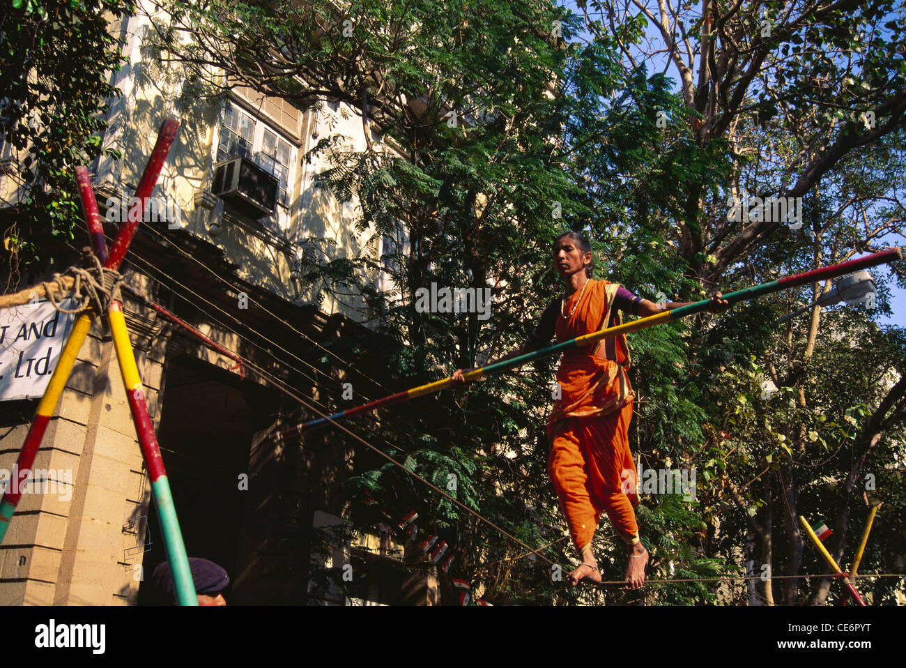 Donna acrobat bilanciamento sulla corda street performance ; Mumbai Bombay ; maharashtra ; India Foto Stock